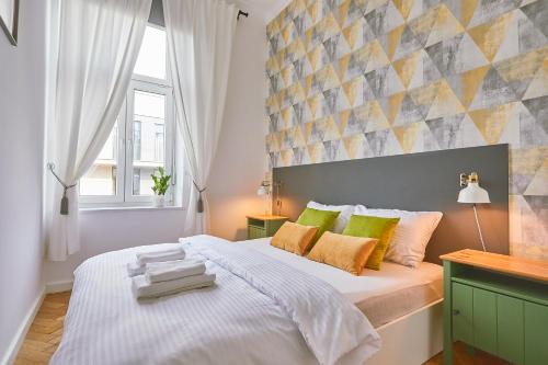 sypialnia z dużym białym łóżkiem z kolorowymi poduszkami w obiekcie Kurkowa GamaHome Cozy Apartments w Krakowie