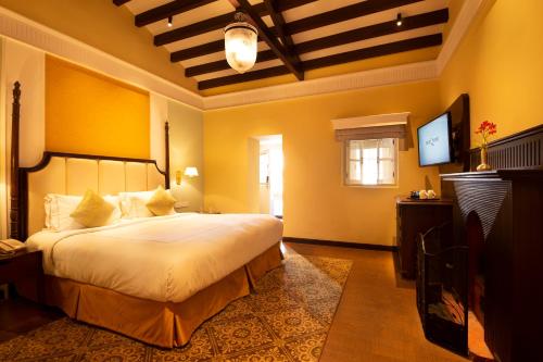 a bedroom with a large bed and a television at Savoy - IHCL SeleQtions in Ooty