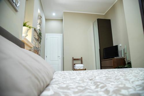 a bedroom with a white bed and a television at House Orlando in Sferracavallo