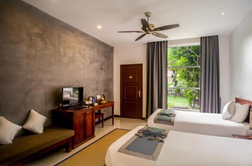暹粒的住宿－Cozy Boutique Villa Siem Reap，酒店客房设有两张床和电视。