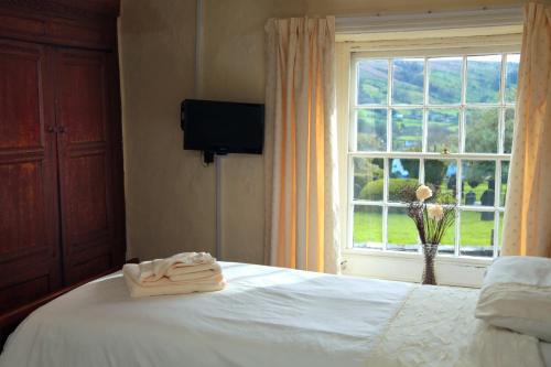 a bedroom with a white bed and a window at The Sun Inn in Dent