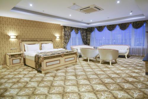 a hotel room with two beds and chairs and curtains at World Point Hotel Istanbul in Istanbul