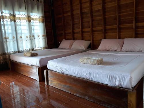 two beds sitting next to each other in a room at บ้านสวนศรเพชร in Phetchabun
