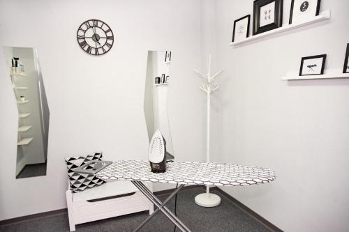 a white room with a table and a clock on the wall at Ibis Poznan Stare Miasto in Poznań