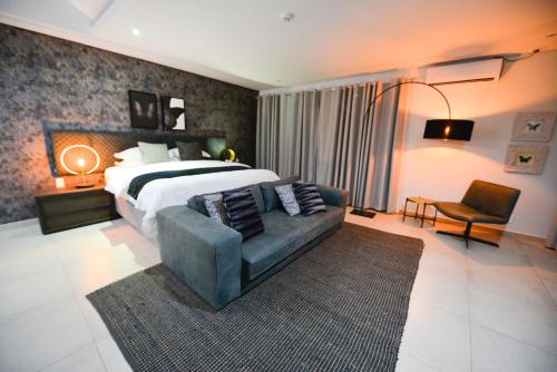 a bedroom with a large bed and a couch at Serurubele Boutique Hotel in Bushbuckridge