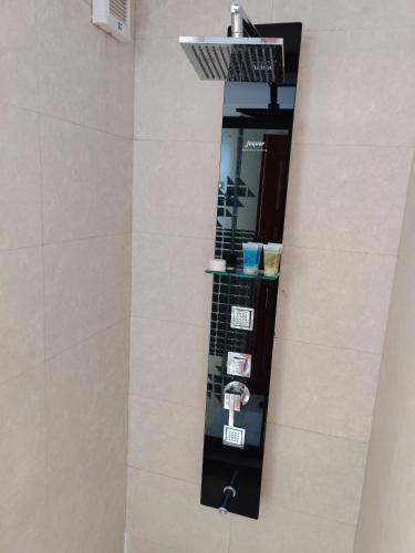 a shower with a glass shelf in a bathroom at Hotel Nikko Towers in Dar es Salaam