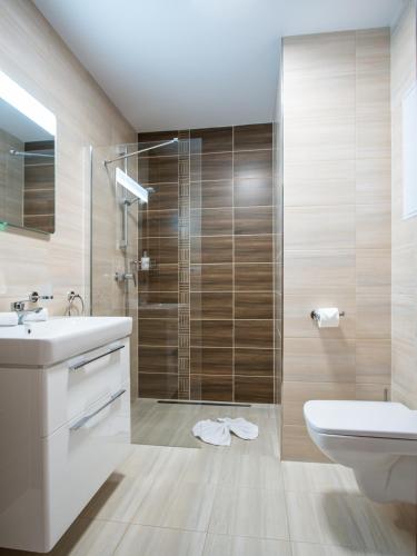 a bathroom with a shower and a sink and a toilet at TATRA SUITES Luxury Studio A302 in Starý Smokovec