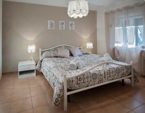 sypialnia z białym łóżkiem i żyrandolem w obiekcie Pomarance Apartment w mieście Pomarance