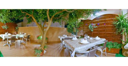a restaurant with tables and chairs and a tree at Villa Midea in Supetar