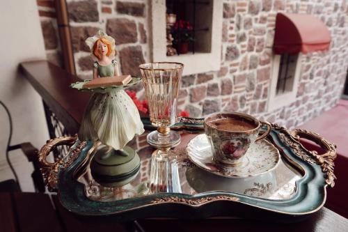 a table with a tray with a doll and a cup of coffee at L'Agora Old Town Hotel & Bazaar in Izmir