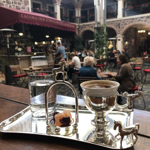 a tray with a glass of water and a cup on a table at L'Agora Old Town Hotel & Bazaar in Izmir