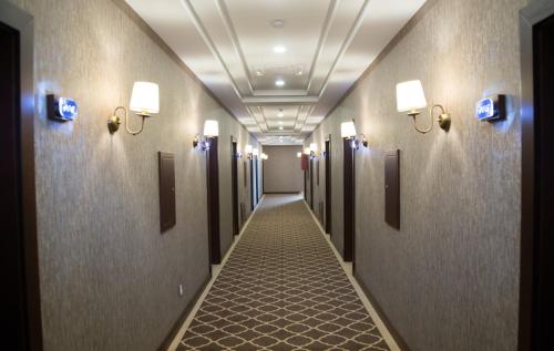 a corridor of a hallway with doors and lights at Macara Sheki City Hotel in Sheki