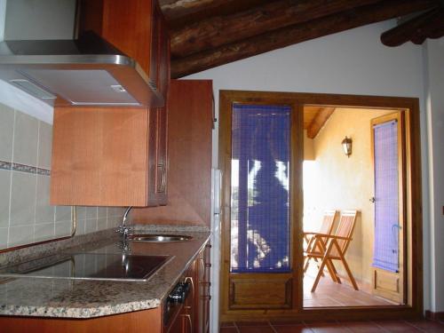 Una cocina con fregadero y puerta a una habitación. en Casa Plana, en Colungo