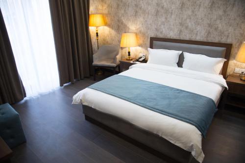 a hotel room with a large bed and a desk at Macara Sheki City Hotel in Sheki