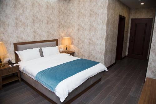 a bedroom with a large bed and two night stands at Macara Sheki City Hotel in Sheki