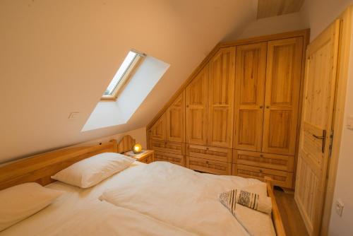 - une chambre avec un grand lit blanc et une lucarne dans l'établissement Vineyard cottage Škatlar 3, à Otočec