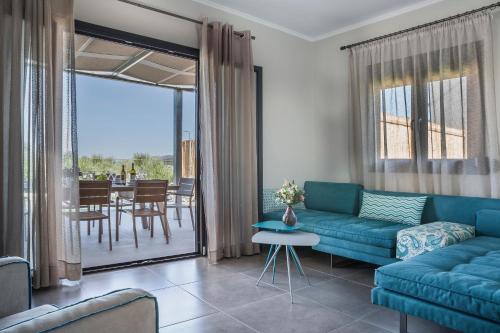 a living room with a blue couch and a table at ONAR - LUXURY VILLAS in Argostoli