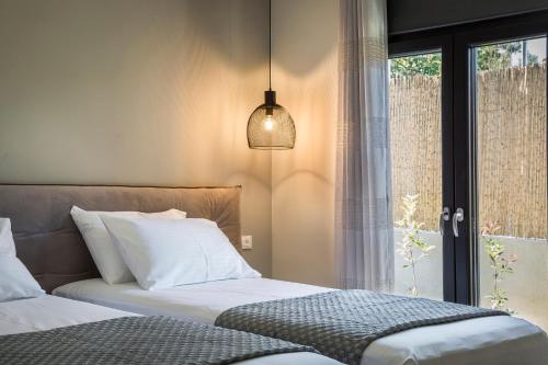 a bedroom with two beds and a window at ONAR - LUXURY VILLAS in Argostoli