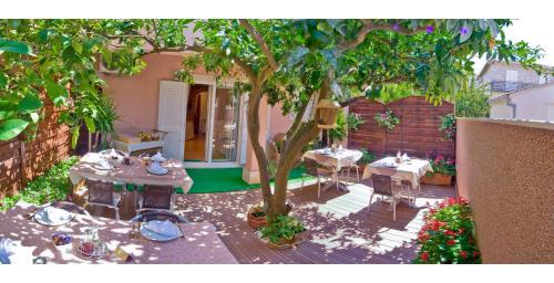a patio with tables and a tree in a backyard at Villa Midea in Supetar