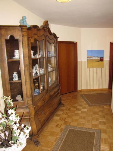 a living room with a large wooden cabinet at Strandhotel-Najade in Borkum