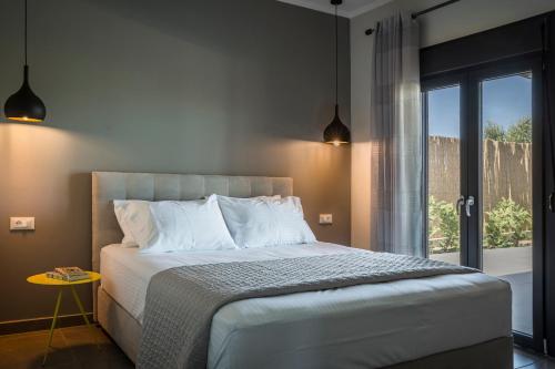 a bedroom with a large bed and a window at ONAR - LUXURY VILLAS in Argostoli