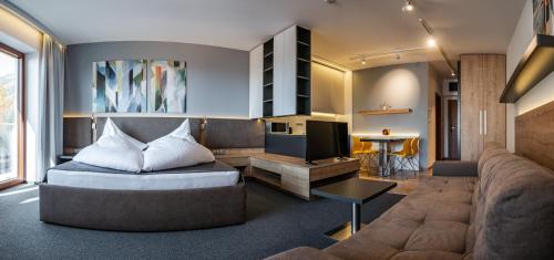 - un salon avec un canapé et une télévision dans l'établissement TATRA SUITES Luxury Studio A302, à Starý Smokovec
