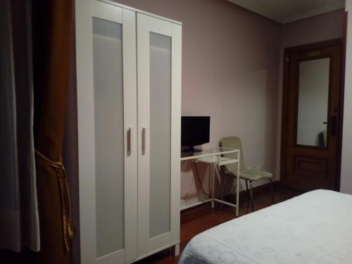 a bedroom with a bed and a desk with a computer at Hostal Álvarez in Oviedo