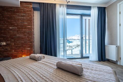 a bedroom with a large bed with a large window at Deer Valley - New Gudauri in Gudauri