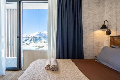 a bedroom with a bed with a view of a mountain at Deer Valley - New Gudauri in Gudauri