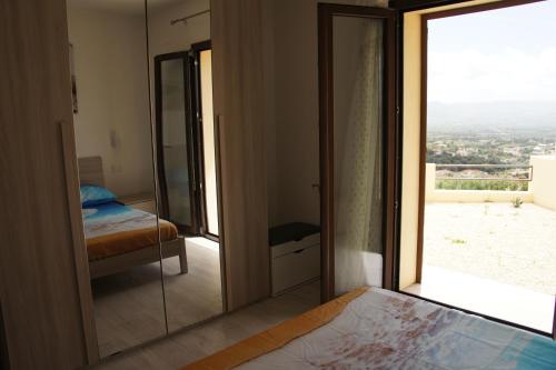 a bedroom with a mirror and a bed and a window at Apartment Mistral in Badesi