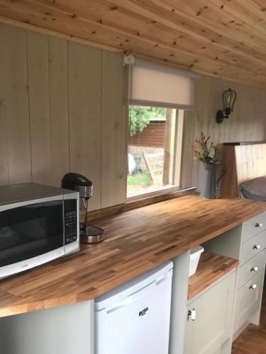 a kitchen with a counter with a microwave and a window at Glamping at Holly Grove Farm in Stoke on Trent
