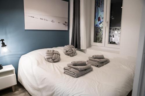 ein weißes Bett mit Handtüchern darüber in der Unterkunft Oyonnappart in Oyonnax