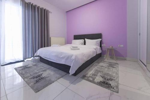 - une chambre avec un grand lit aux murs violets et aux tapis dans l'établissement Modern fully-equipped house, 5 min walk from metro, à Athènes