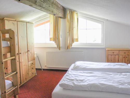 a bedroom with two beds and two windows at Chalet Rotenstein in Berwang
