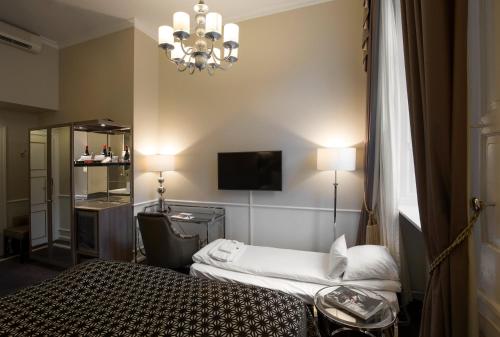 een hotelkamer met een bed en een kroonluchter bij Phoenix Copenhagen in Kopenhagen