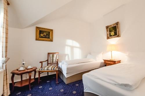 a hotel room with two beds and a chair at Historische Spitzgrundmühle in Coswig
