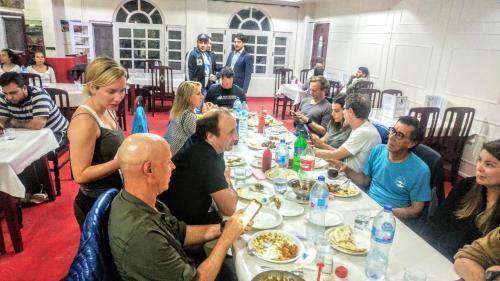 a group of people sitting around a table eating food at Hotel Dewanekhas Skardu in Skardu