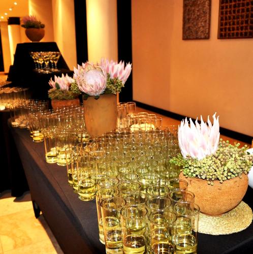 a table filled with wine glasses and potted plants at Premier Hotel Midrand in Midrand