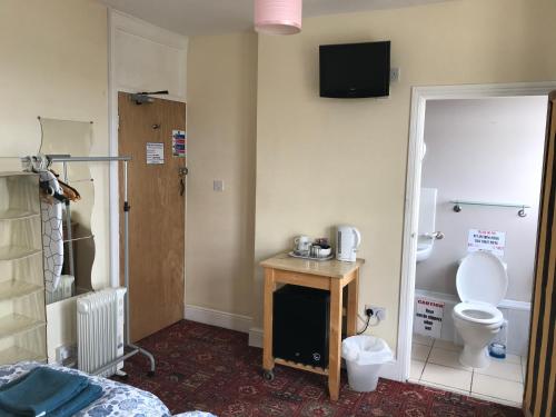 a room with a bathroom with a toilet and a sink at Bayside Guest House in Porthcawl