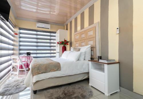 a bedroom with a large bed and a window at SelaMod Village Guest House in Tshaneng