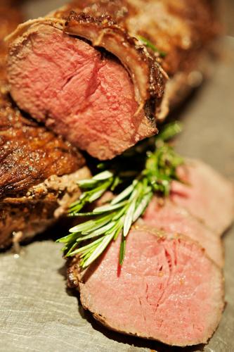 a close up of two slices of meat with greens on it at Premier Hotel Midrand in Midrand