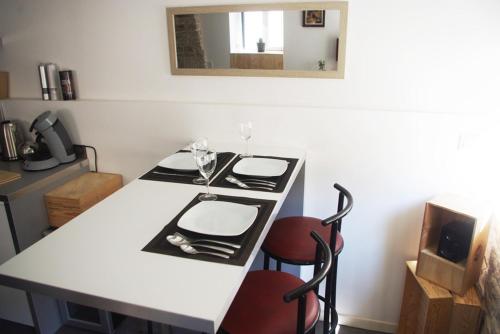 a white table with two glasses and a mirror at Wood Stone and Wine in Beaune