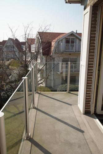 a walkway leading to a house with a balcony at Oostduinkerke Apartments in Oostduinkerke
