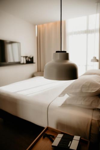 a bedroom with a bed with a remote control on a table at Casa Elliot Hotel in Barcelona