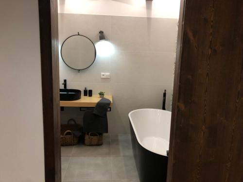 a bathroom with a tub and a sink and a mirror at Vall del Riu - Llar dolça llar HUT07815 in Soldeu