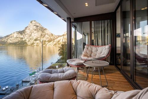 a room with a view of the water and mountains at Das Traunsee - Das Hotel zum See 4 Stern Superior in Traunkirchen