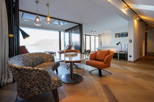 a living room filled with furniture and a large window at Seehotel Das Traunsee in Traunkirchen