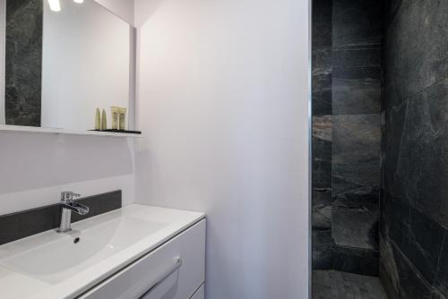 a bathroom with a white sink and a mirror at Honorê - Suite Barre in Lyon