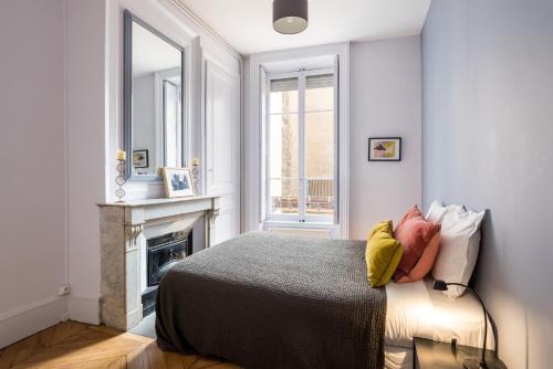 a bedroom with a bed with a fireplace and a mirror at Honorê - Suite Barre in Lyon