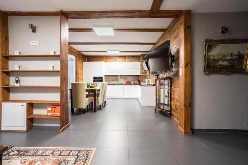 a living room with a television and a kitchen at Domek pod Warszawą z sauną in Raszyn